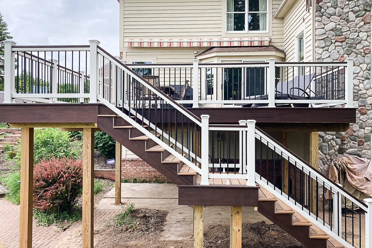 Trex Transcend deck rebuild in Pittsfield Township with stairs and landing, featuring Trex Transcend Havana Gold decking, Lava Rock fascia, Trex Transcend posts and Trex Select white railing, and black aluminum balusters